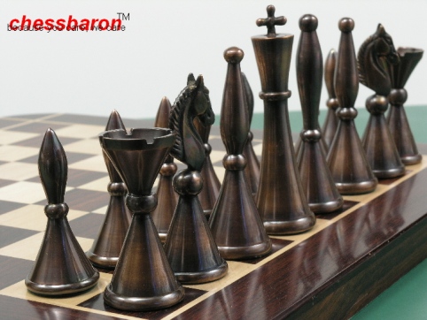 A luxury metal chess set with polished steel, copper and brass pieces arranged on a traditional chess board